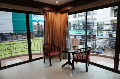 a room with a table and two chairs and a balcony at Centre Point Nanai in Patong Beach
