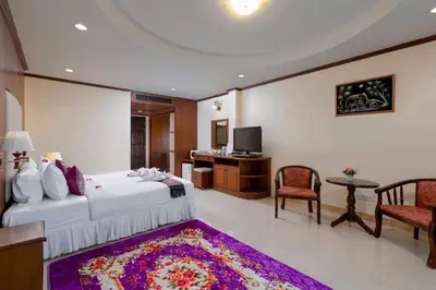 a bedroom with a bed and a desk and a television at Centre Point Nanai in Patong Beach