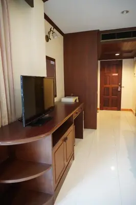 a living room with a television on a wooden desk at Centre Point Nanai in Patong Beach