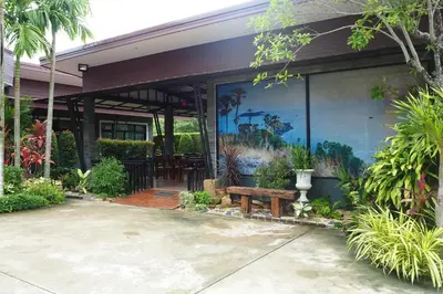 a building with a table and a bench in front of it at Jinda Resort in Nai Yang Beach