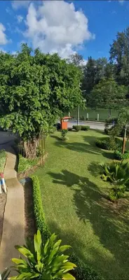 a park with green grass and trees and a sidewalk at Two bedroom apartment near Naiharn beach in Nai Harn Beach