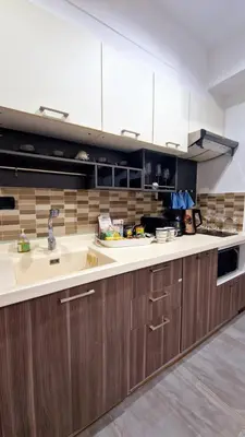 a kitchen with a sink and wooden cabinets at Two bedroom apartment near Naiharn beach in Nai Harn Beach