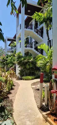 a white building with a pathway in front of it at Two bedroom apartment near Naiharn beach in Nai Harn Beach
