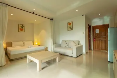 a bedroom with a bed and a couch and a table at Cozy 1BR Poolside Apartment with Scenic Balcony C132 in Surin Beach