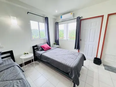 a bedroom with a bed with a pink pillow on it at KLApartment in Ban Bang Chak