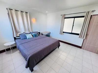 a bedroom with a large bed and a window at KLApartment in Ban Bang Chak