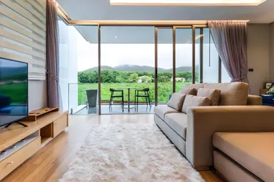 a living room with a couch and a television at Modern Pool Villa in Chalong in Chalong