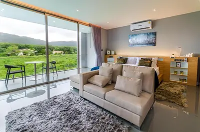 a living room with a couch and a large window at Modern Pool Villa in Chalong in Chalong