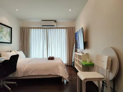 a bedroom with a bed and a television and a chair at Rawai Beachfront - Studio room on 2 floor in Rawai Beach