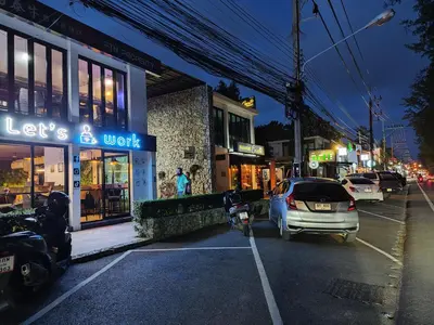 a parking lot with a car parked in front of a store at Rawai Beachfront - Studio room on 2 floor in Rawai Beach