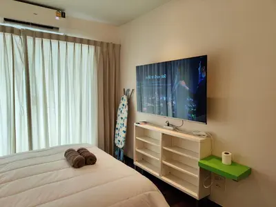 a bedroom with a bed and a flat screen tv at Rawai Beachfront - Studio room on 2 floor in Rawai Beach