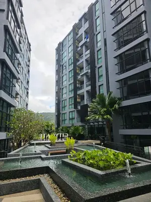 a view of two tall buildings with a garden at 1BDR 2 Pools on the roof 500m to beach 3 Bars in Kamala Beach