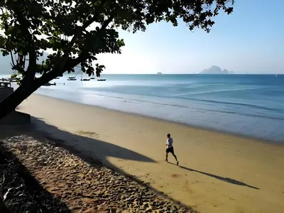 a man walking on the beach at xx GO INN Ao Nang Krabi - โกอินน์ อ่าวนาง กระบี่ Aonang in Ban Khlong Haeng