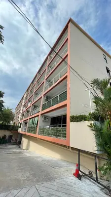 a large apartment building with a red at Rawai beach condominium \u62c9\u8587\u6d77\u6ee9\u9152\u5e97\u516c\u5bd3 in Nai Harn Beach