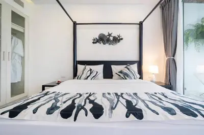 a bedroom with a bed with a black and white bedspread at Patong WiN HOUSE Villa in Patong Beach
