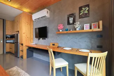 a kitchen with a wooden table and chairs at Relife Windy B226 at NaiHarn beach by CapitalPro in Phuket Town