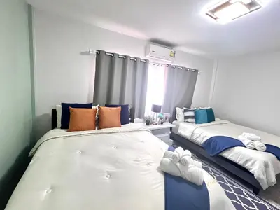 a bedroom with two beds and a window at Comfort Home Patong in Patong Beach