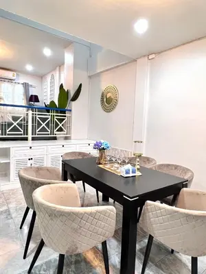 a dining room with a black table and chairs at Comfort Home Patong in Patong Beach
