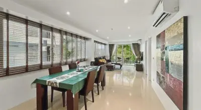 a dining room with a green table and chairs at Sunset Plaza Condominium in Karon Beach