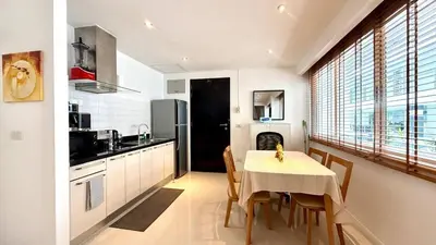 a kitchen and dining room with a table and chairs at Sunset Plaza Condominium in Karon Beach
