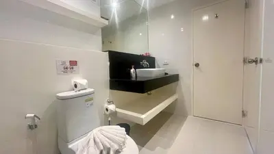 a white bathroom with a sink and a toilet at Sunset Plaza Condominium in Karon Beach