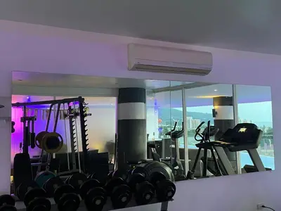 a room with a gym with a large mirror at Sunset Plaza Condominium in Karon Beach