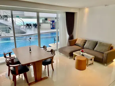 a living room with a couch and a table at Sunset Plaza Condominium in Karon Beach