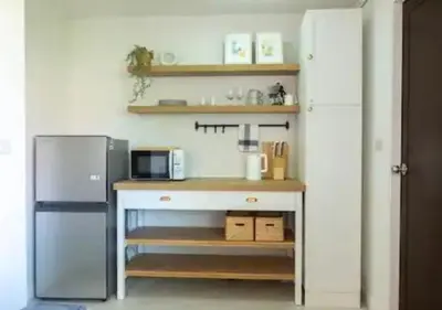 a small kitchen with a refrigerator and a counter at Mango Moon Phuket Tropical 2BR near Central Phuket in Ban Rangeng