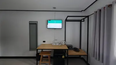 a room with a table and a television on a wall at Jong's House- Phi Phi Island in Phi Phi Don