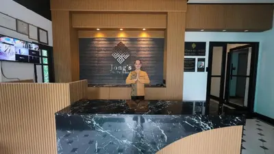 a man standing in front of a counter in a restaurant at Jong's House- Phi Phi Island in Phi Phi Don