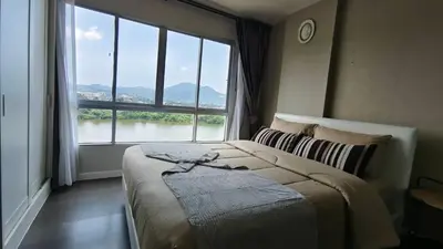a bedroom with a bed and a large window at Dcondo mine Kathu Phuket in Kathu