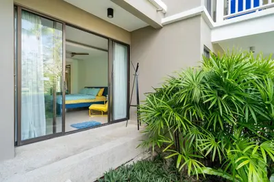 a house with sliding glass doors and plants at Allamanda Laguna Phuket in Laguna Phuket