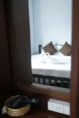 a mirror reflection of a bed in a bedroom at Amahostel in Ban Thalat Choeng Thale