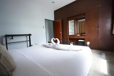 a bedroom with a white bed with swans on it at Amahostel in Ban Thalat Choeng Thale
