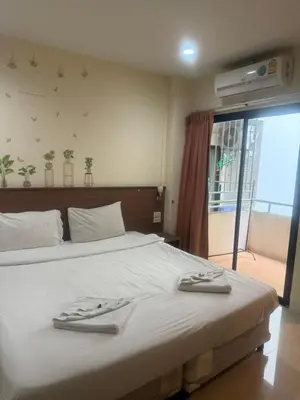 a bedroom with a bed with two towels on it at Royal Waves Hotel in Patong Beach