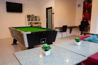 a pool table in a room with two potted plants at Royal Waves Hotel in Patong Beach