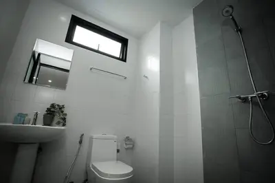 a bathroom with a shower and a toilet and a sink at Royal Waves Hotel in Patong Beach
