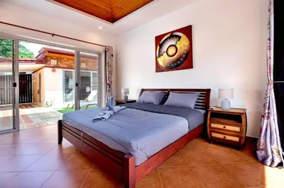 a bedroom with a bed and a large window at Balinese 3BR Pool Villa Freya, Spacious Courtyard, 70 m from Stay Wellbeing & Lifestyle in Rawai Beach
