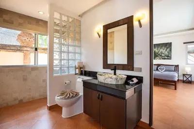 a bathroom with a sink and a toilet and a mirror at Balinese 3BR Pool Villa Freya, Spacious Courtyard, 70 m from Stay Wellbeing & Lifestyle in Rawai Beach