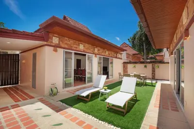 a patio with two chairs and a lawn at Balinese 3BR Pool Villa Freya, Spacious Courtyard, 70 m from Stay Wellbeing & Lifestyle in Rawai Beach