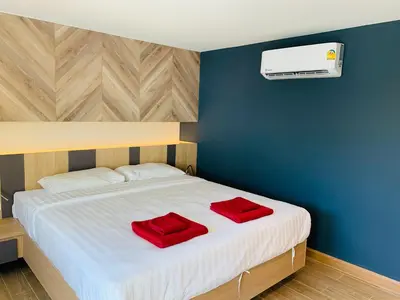 a bedroom with a bed with two red pillows on it at Room Actually in Karon Beach