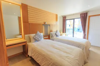 a hotel room with two beds and a mirror at Room Actually in Karon Beach
