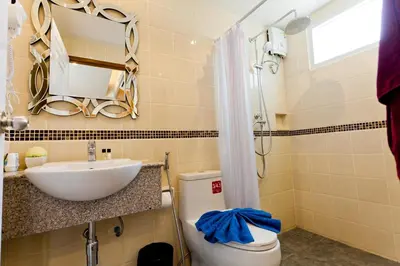 a bathroom with a sink and a toilet and a mirror at Room Actually in Karon Beach