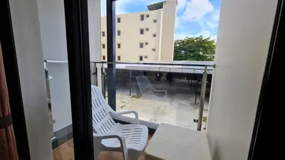 a balcony with two chairs and a view of a building at Room Actually in Karon Beach