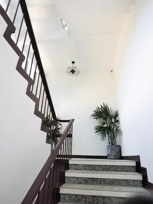 a staircase with two potted plants in a room at Siri Hotel Phuket in Phuket Town