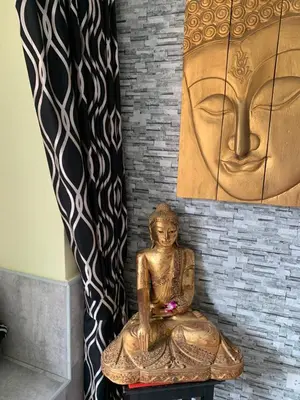 a statue sitting on a table in front of a wall at Fong Kaew and Baan Nang Fa Guesthouse in Patong Beach