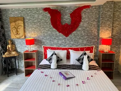 a bedroom with a bed with a red head board at Fong Kaew and Baan Nang Fa Guesthouse in Patong Beach