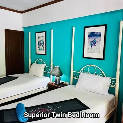 a bedroom with two beds and a blue wall at Successive BeachFront ,Krabi in Ban Khlong Haeng