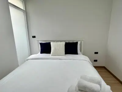 a white bed with blue pillows in a bedroom at 2 BR Modern Pool Villa Chalong in Ban Suan