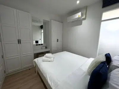 a bedroom with a white bed with towels on it at 2 BR Modern Pool Villa Chalong in Ban Suan